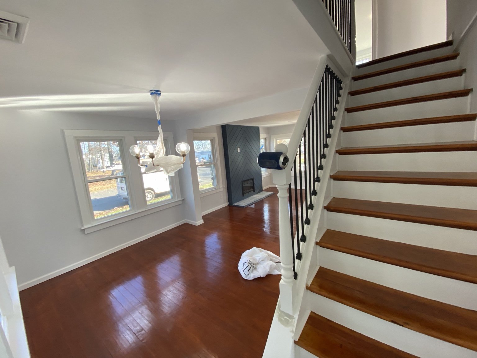 Finished living and dining area with wood flooring and a staircase