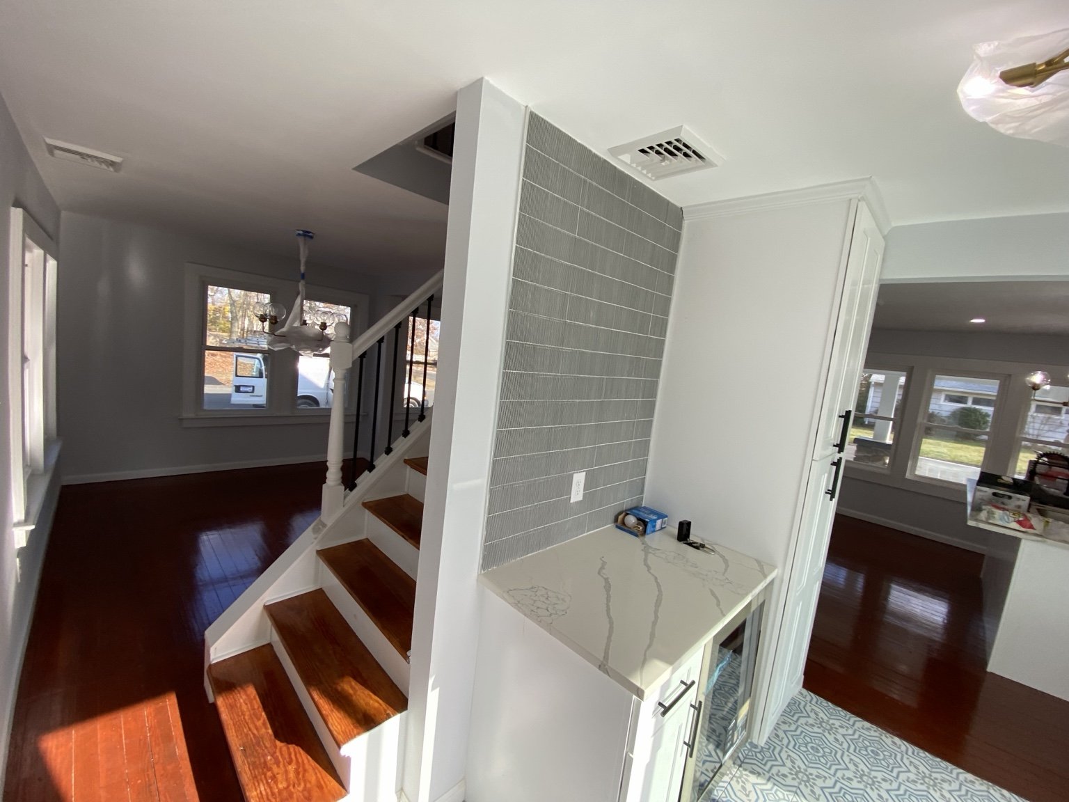 Finished interior with a tiled partition, wood floors, and white trim