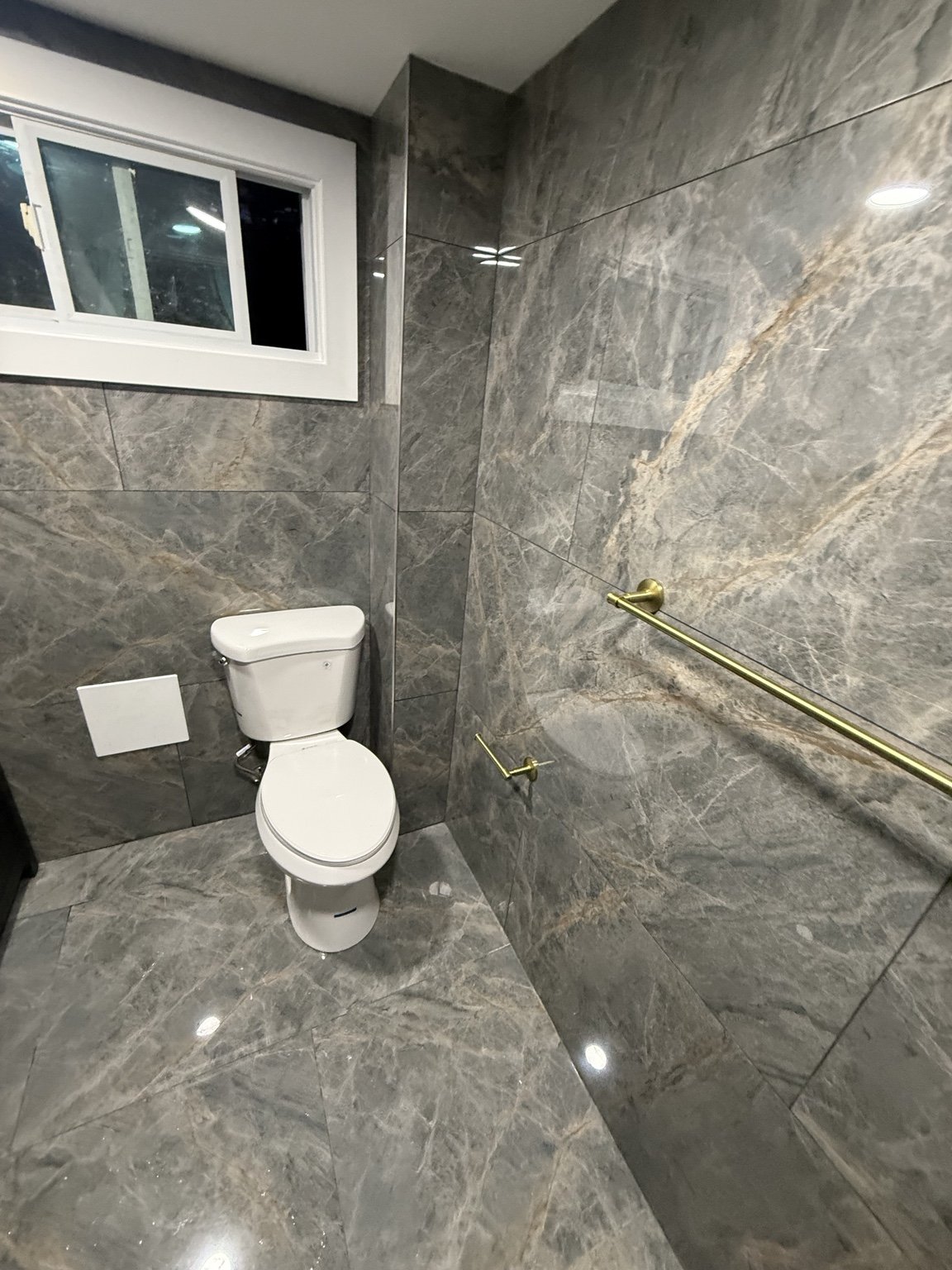 Tiled bathroom with window and shower fixtures
